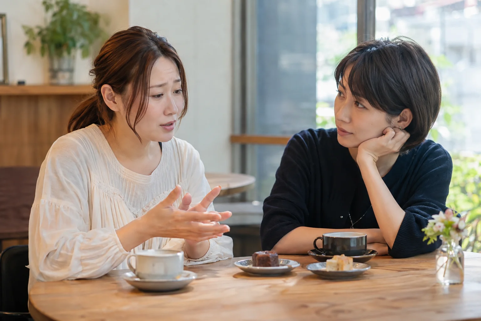 カフェで恋愛の悩みを信頼できる友人に話す二人の日本人女性